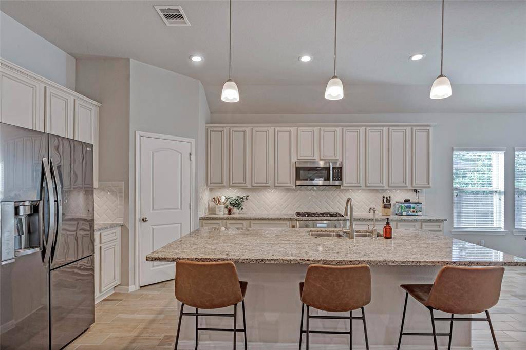 The kitchen has gorgeous granite and backsplash.