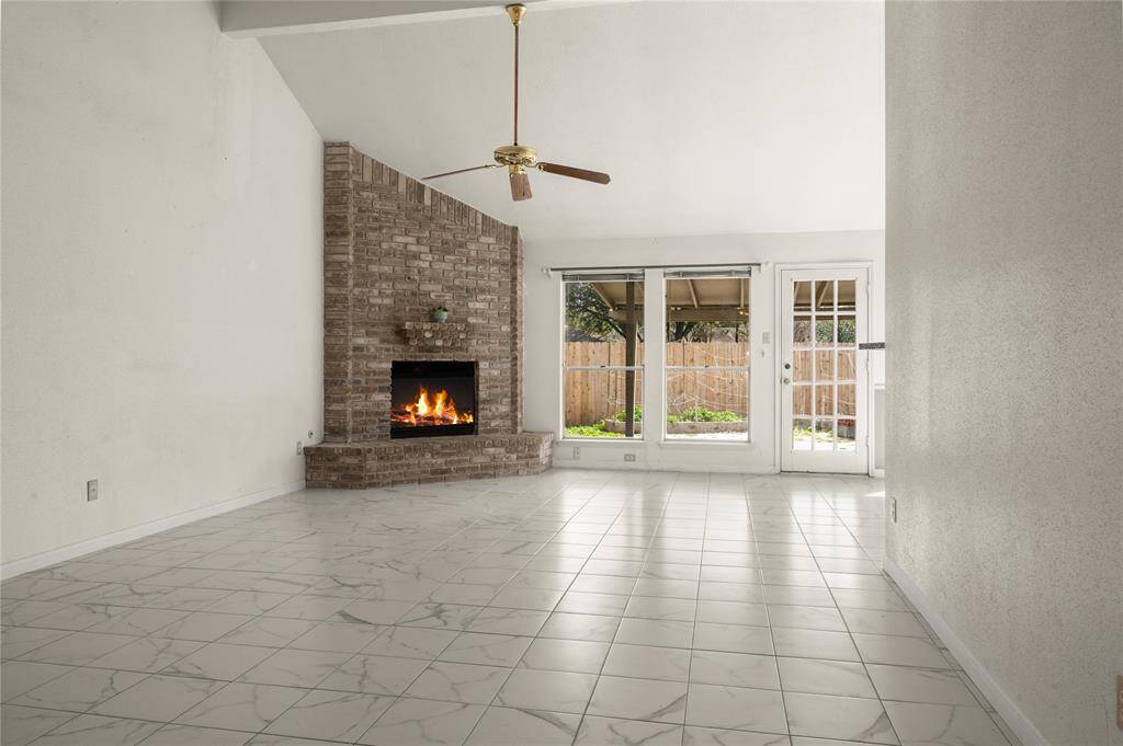 The expansive family room boasts high vaulted ceilings, ceiling fan, large gas or wood burning fireplace with a handsome brick mantle, fireplace surround and surrounding hearth.