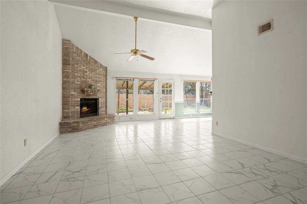 The wall of windows extends from the family room into the breakfast area through which the considerably-sized covered back patio, garden and play area can be seen.