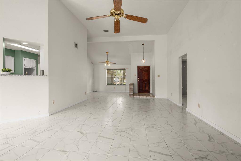 This view from the corner of this great room shows the formal dining room's accessibility to the kitchen and family room.  The secondary bedrooms and full bathroom are just through the entryway to your right.