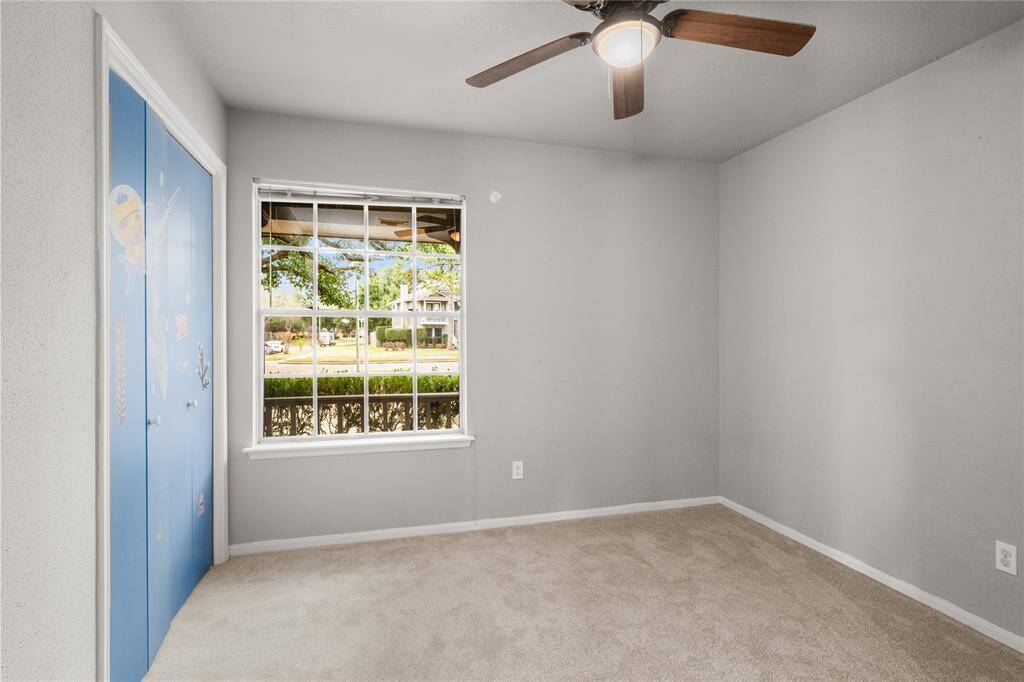 The two secondary bedrooms are situated on either side of the secondary bathroom.  This secondary bedroom has an attractive 5-blade ceiling fan, recent carpet, a sizeable closet and this magnificent window.