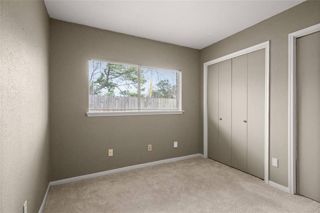 An elongated sliding window, two closets, recent carpet and crisp clean lines of the white wood trim against the lovely wall color produce a striking secondary bedroom.
