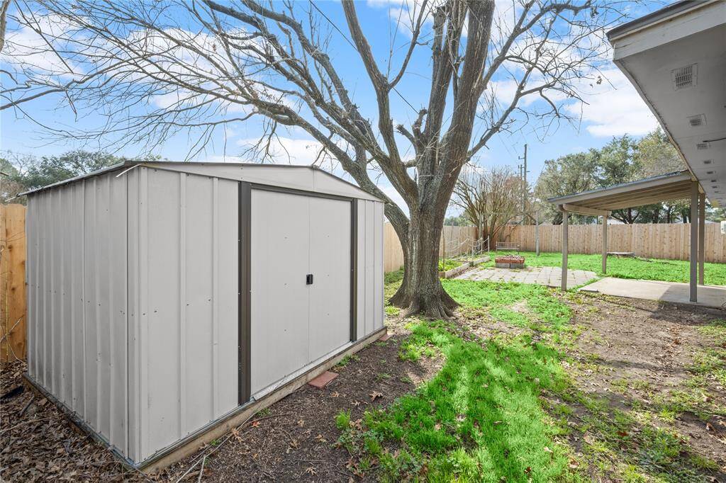 This is a spectacular view of the huge backyard with this massive 2021 shed to store all your lawn equipment.  The very recent, 2024 side and rear fence replacement and the sizeable, covered patio, paver extensions and a firepit are on clear display.  Also recently installed raised garden beds are located along the rear fence and the side yard.