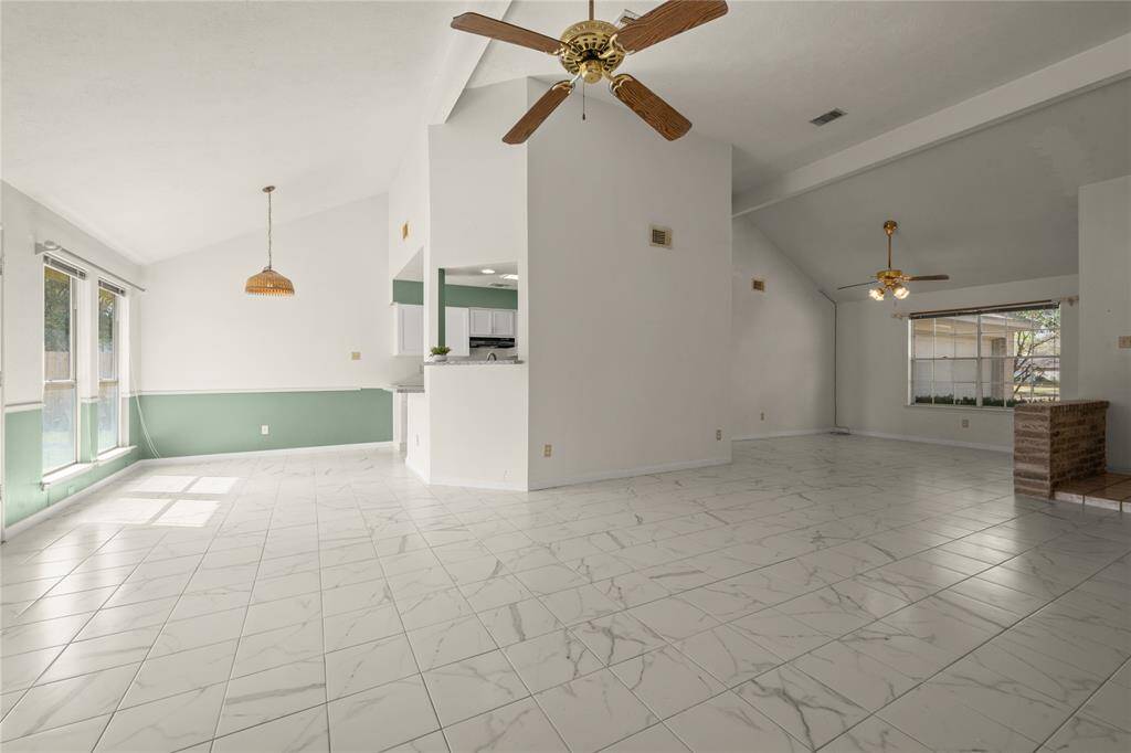 The panoramic view of this open, multi-roomed space with its double-beamed ceiling displays this home's extensive living area. The large breakfast area and breakfast bar are to the left and lead to the updated 2024 kitchen. The huge dining area is just to the right.