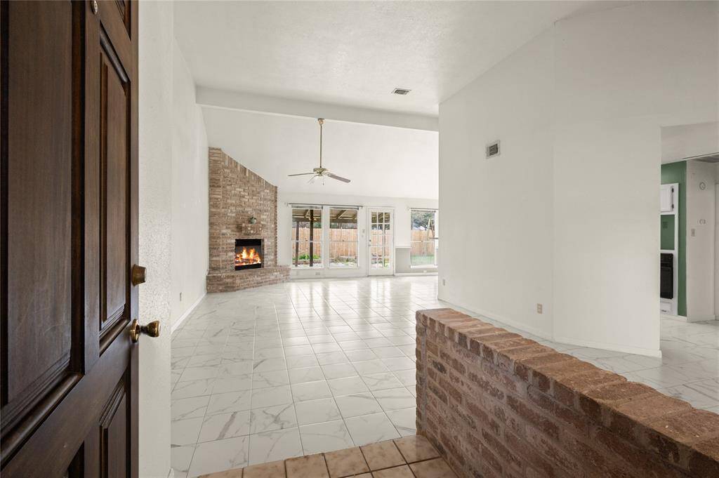 Upon entering, your guests are greeted by this warm, inviting foyer with an expansive family room containing a floor-to-ceiling brick fireplace and hearth.