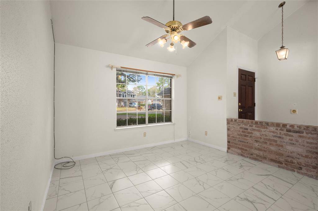 This is another view of the spacious formal dining room. Its beautiful white tile flooring with tastefully designed veins of gray running through it creates a very light and bright room.
