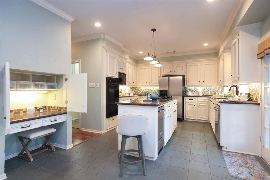 The custom-built kitchen combines functionality and timeless design. Designed with ample storage, it features floor to ceiling cabinetry that provides generous space for organizing kitchen essentials and cookware!  To the left is the open cubby now used for daily home business!