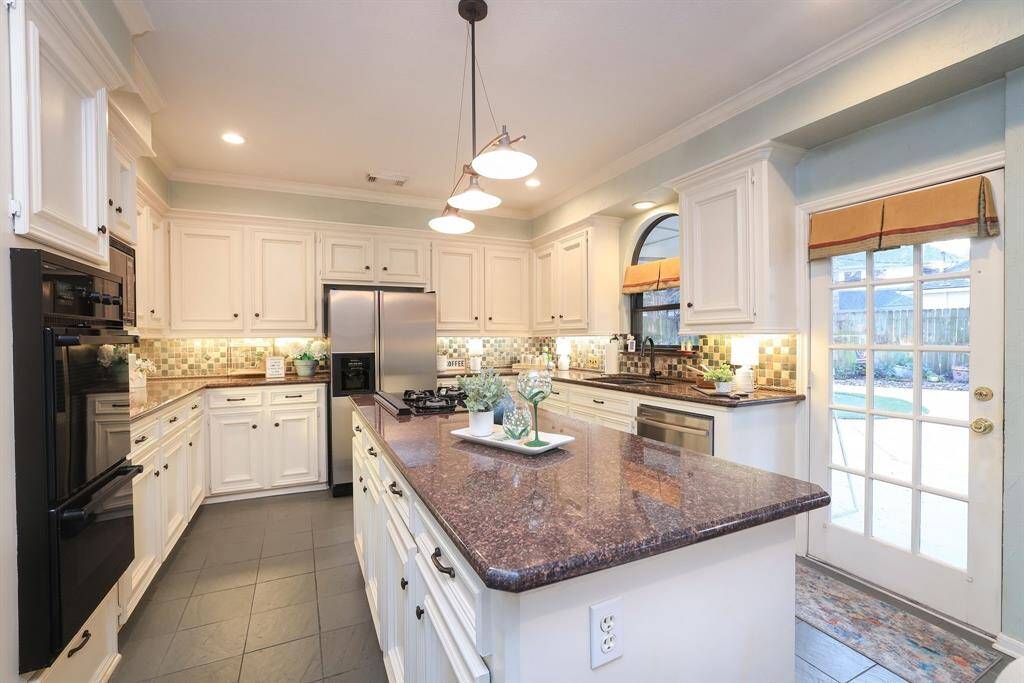A room full of appliances, including a double oven, gas stove top, microwave, dishwasher and new Kitchen Aid ice maker!   The island with granite counter top makes the perfect area to prepare meals!