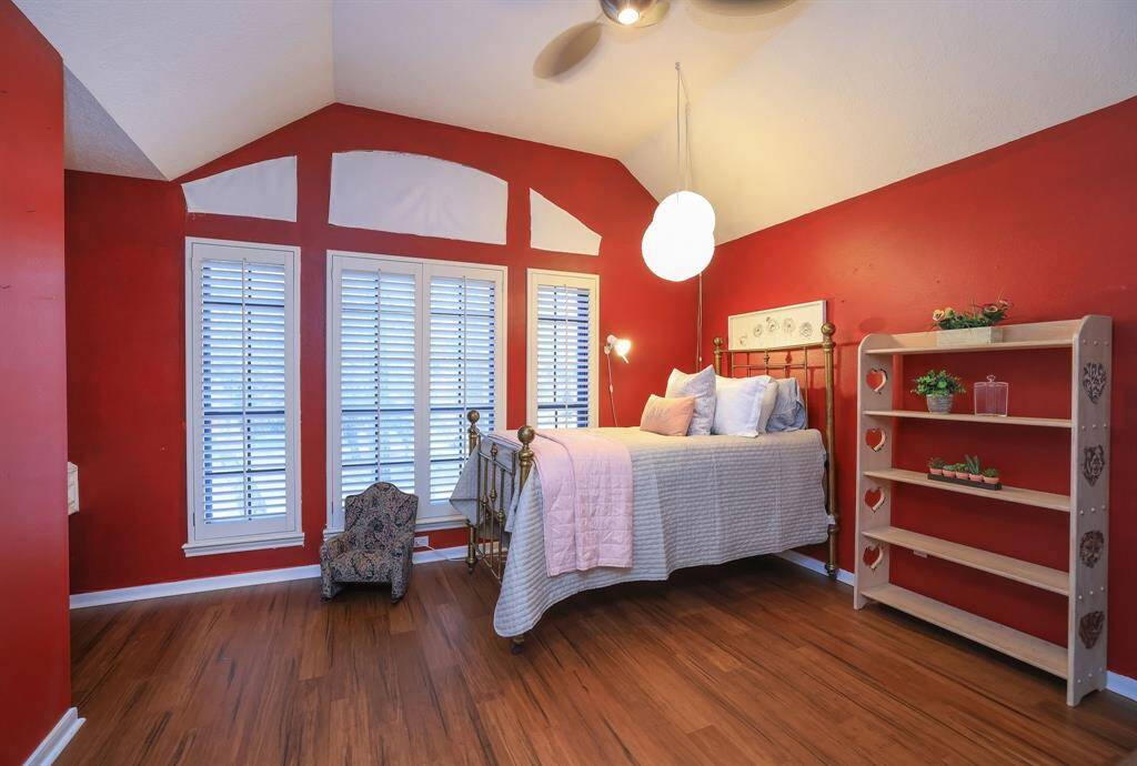 This sweet secondary bedroom is located upstairs and has wood flooring and a built in desk with shelving for those busy homework nights!  Plantation shutters enhance the wall space and overlook the lush landscaping in the front of the home!