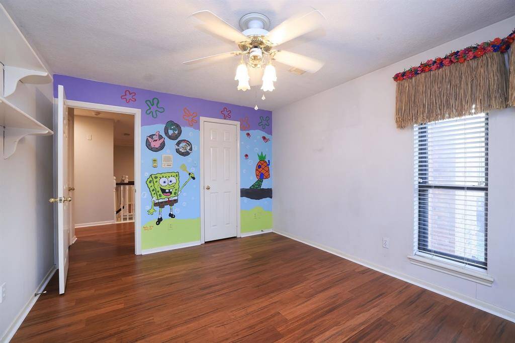 You can own this Krusty Krab!  This adorable bedroom has the cutest vibe!  Wood flooring, walk in closet, wall shelving and grass skirts for decorative valences!  This room offers so much imagination!