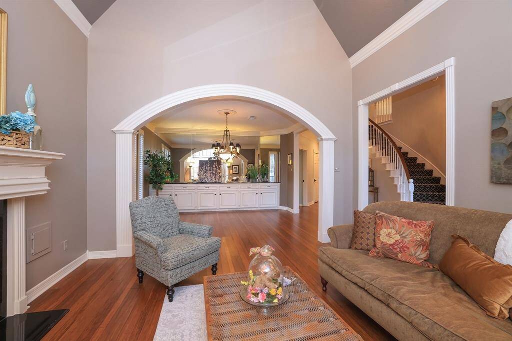 The arched open wall space seamlessly transitions the living space to the dining room.  The entrance is just to the right with the stairwell in sight. Please take note of the vast moldings that frame the doors & entrances to each room!