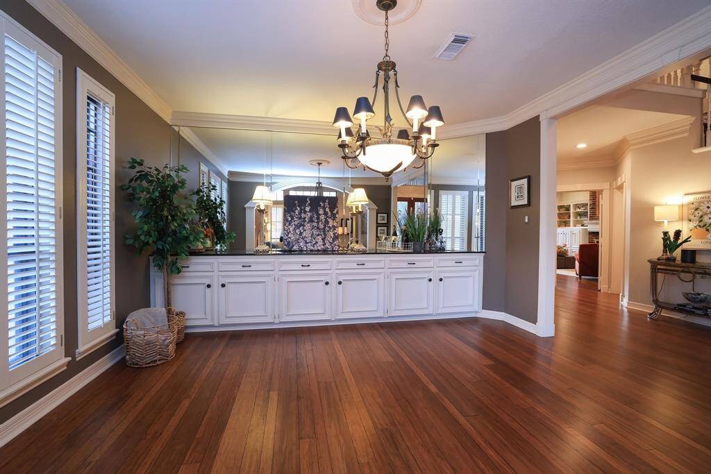 This elegant dining room features a unique chandelier and a built in wall unit with a glass wall feature.  The natural light comes from large windows with decorative plantation shutters.  This dining room is perfect for holiday dinners or just a quiet romantic night for two!