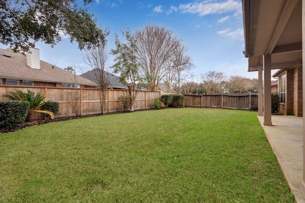 Spacious backyard with well-maintained lawn and wooden fencing, offering privacy and a great outdoor space for relaxation or entertaining.