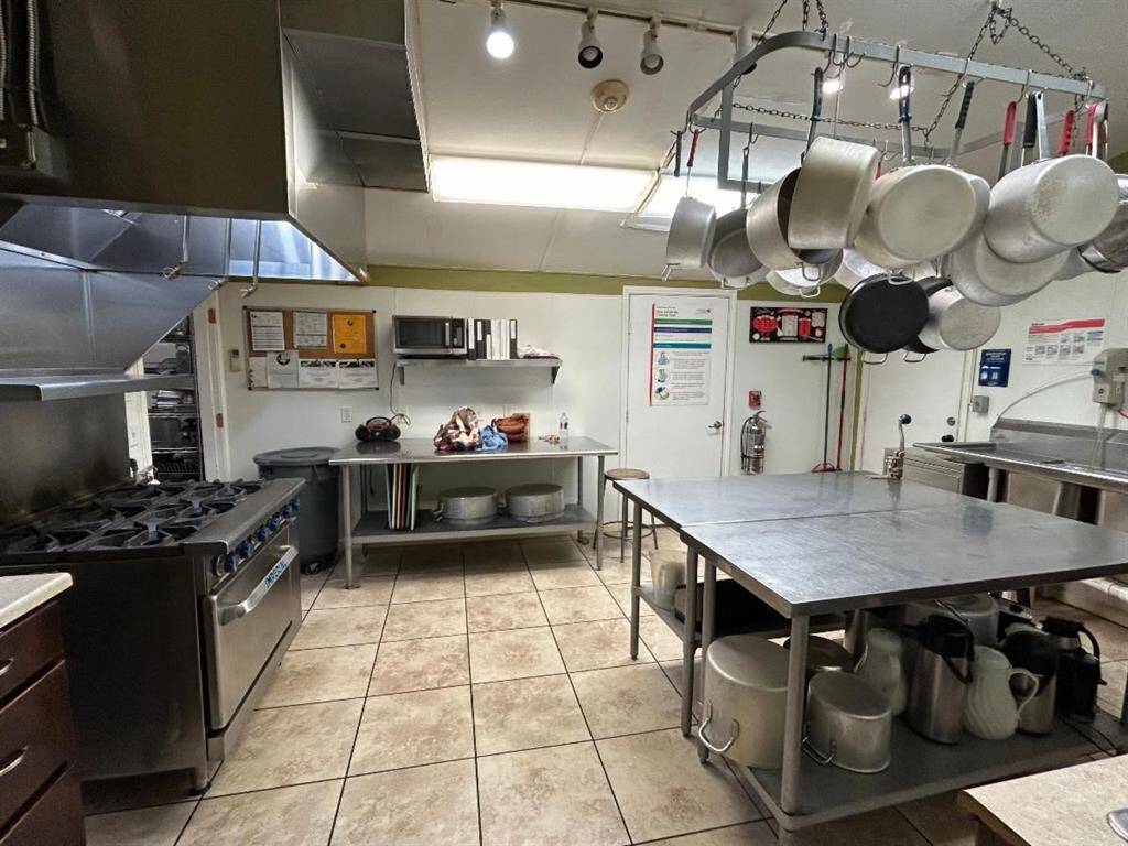 This commercial kitchen is equipped with professional-grade appliances, including a large stove, multiple sinks, and plenty of counter space.