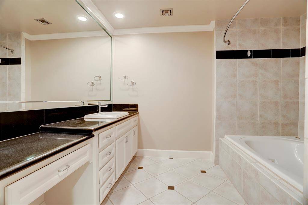 Relax and unwind in this bathroom, featuring a soothing jetted tub/shower combo for the ultimate comfort. With plenty of cabinets for all your storage needs, it’s both a functional and tranquil space to enjoy.