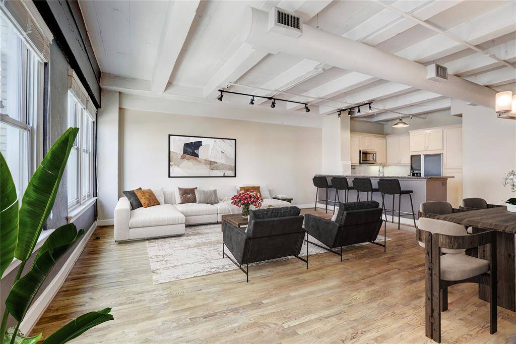 The living space flows effortlessly, providing plenty of room for gatherings and relaxation! The large windows to the left fill the room with natural light. This photo is virtually staged.