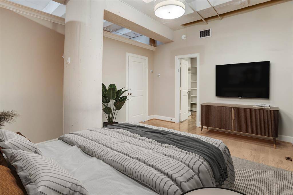 Another angle of the primary bedroom, where you can spot the door to the left leading to a spacious walk-in closet. It’s a great feature, offering plenty of storage and organization space. This photo is virtually staged.