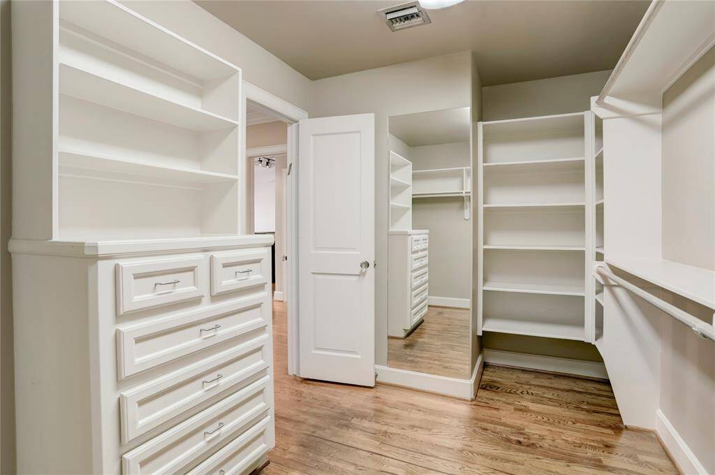 The large walk-in closet is a dream, featuring built-in shelves and plenty of hanging racks to accommodate all your storage needs. It offers ample space to keep everything organized and easily accessible—perfect for creating a neat, clutter-free wardrobe area.
