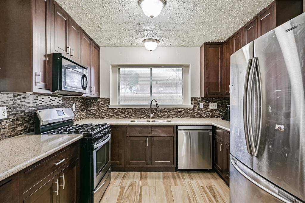 Newly remodeled kitchen featuring tall cabinets with plenty of storage space, gas cooktop, sleek counters and porcelain flooring