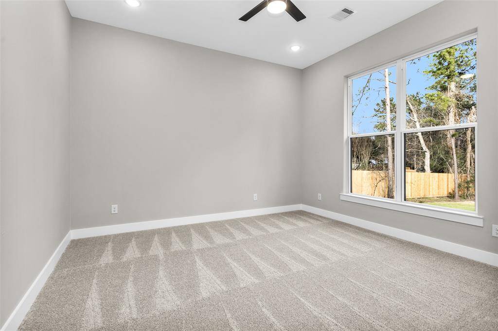 A secondary bedroom with a large closet and bright windows, offering a versatile space for guests or family members.