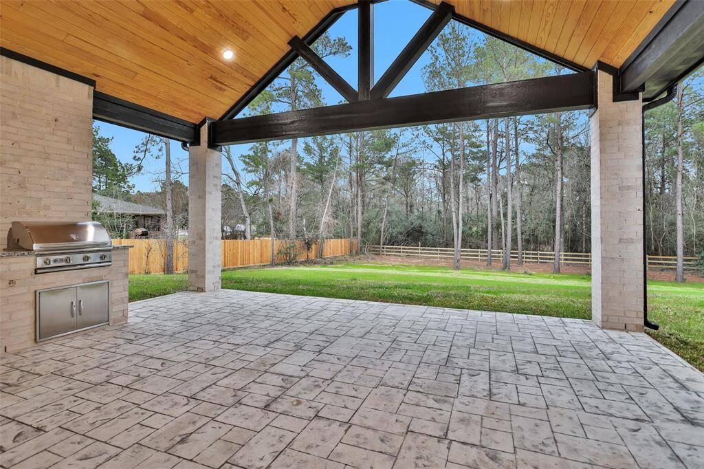 A covered back patio with seating arrangements, perfect for entertaining and outdoor dining.