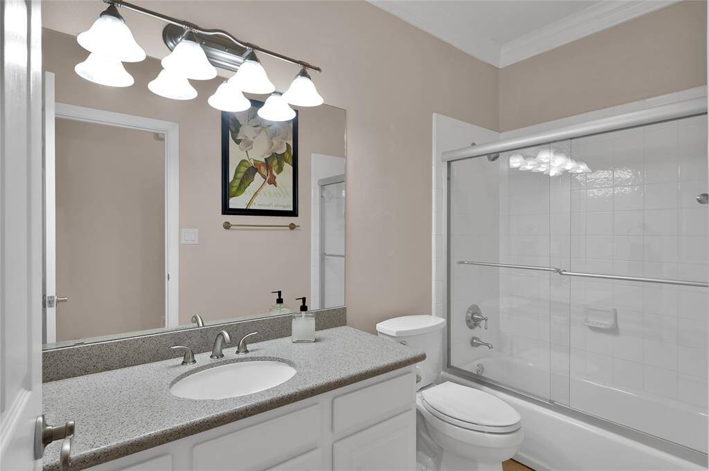 Just off the kitchen, the laundry room is equipped with multiple cabinets for storage of cleaning products, a folding counter, a window providing natural light and space for an additional fridge or freezer inside the home.