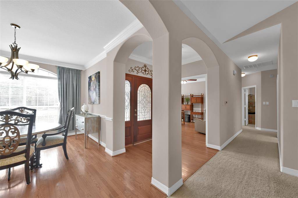 The welcoming entryway with elegant arched doorways and hardwood floors opens to the dining room to the left.