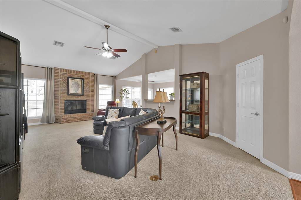 Just off the foyer, you enter the living room featuring a high vaulted ceiling, and floor plug for your lamps and other electrical needs. The wood burning fireplace is encased by a beautiful brick surround and hearth for our chilly Texas days.