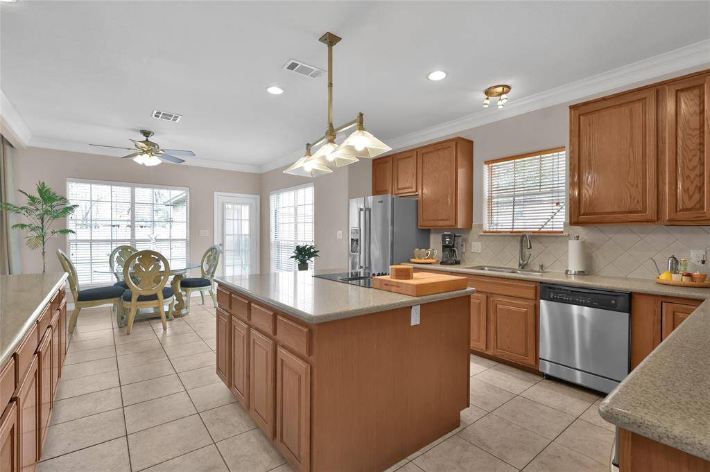 The informal eating area connects to the kitchen with a view of the back yard and the living room. Access the back yard and garage through the glass door.