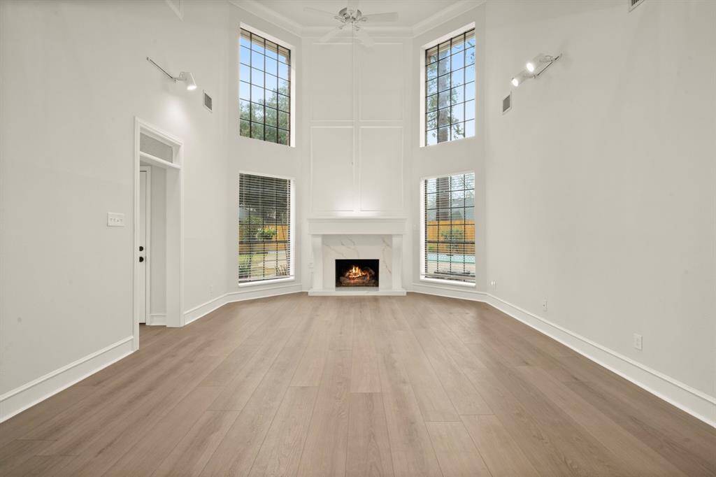 Step into the heart of the home, where soaring 18ft ceilings and a grand paneled fireplace create an atmosphere of warmth and sophistication.