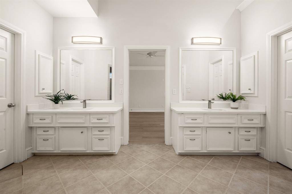 The ensuite spa bath boasts a luxurious Jacuzzi tub, sunken step-in shower, and double quartz vanities.