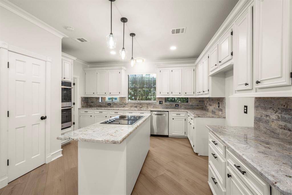 This chef’s kitchen is a masterpiece, boasting double ovens, an electric cooktop island, and a built-in spice rack for ultimate functionality.