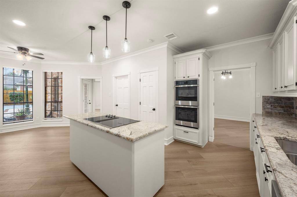Stunning granite countertops and custom cabinetry provide a sleek yet warm aesthetic.