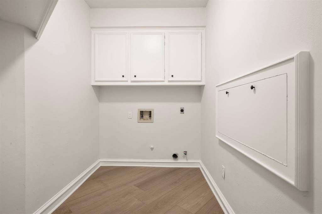 Designed for efficiency, the laundry room offers plenty of counter space for folding and organizing. Built-in cabinetry provides extra storage to keep essentials tucked away.