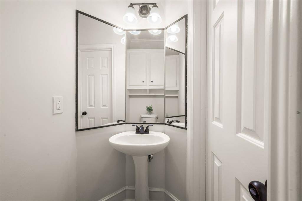 A stylish half bath on the main level ensures convenience for guests while maintaining privacy for the home’s residents.
