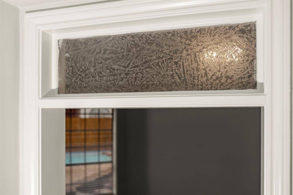 Graceful transom windows above the doors elevate the home’s design, allowing natural light to dance through each space.