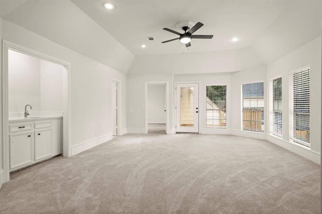 The game room is an entertainer’s paradise, featuring a sleek wet bar with quartz countertops. A spacious layout allows for endless fun, whether hosting game nights or relaxing with family.