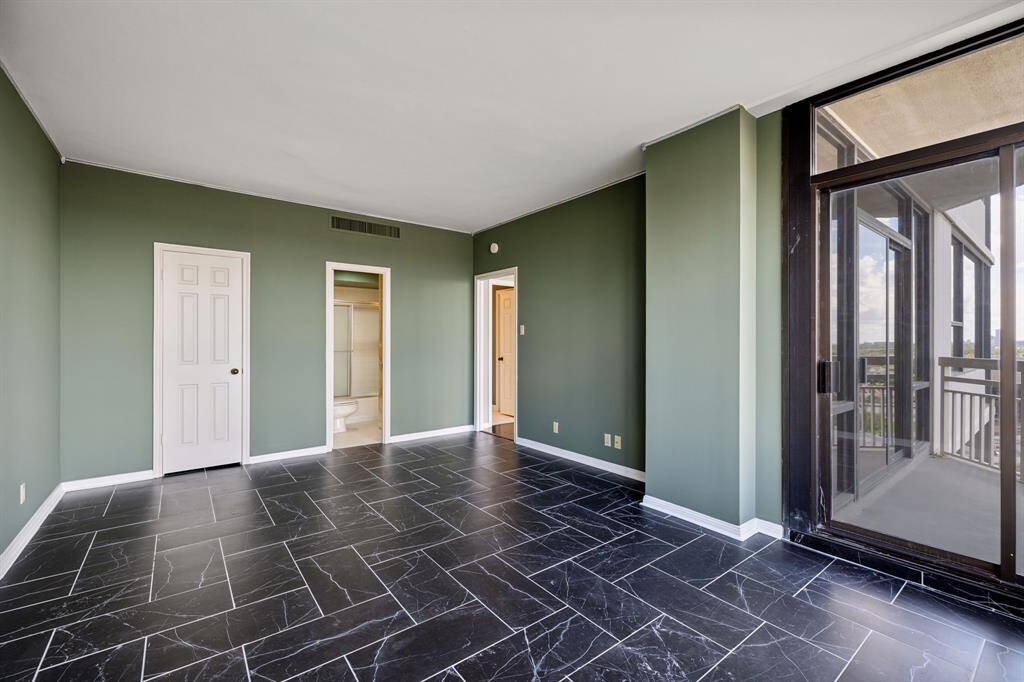 Another view of the bedroom with a walk-in closet, bathroom access and private balcony access.