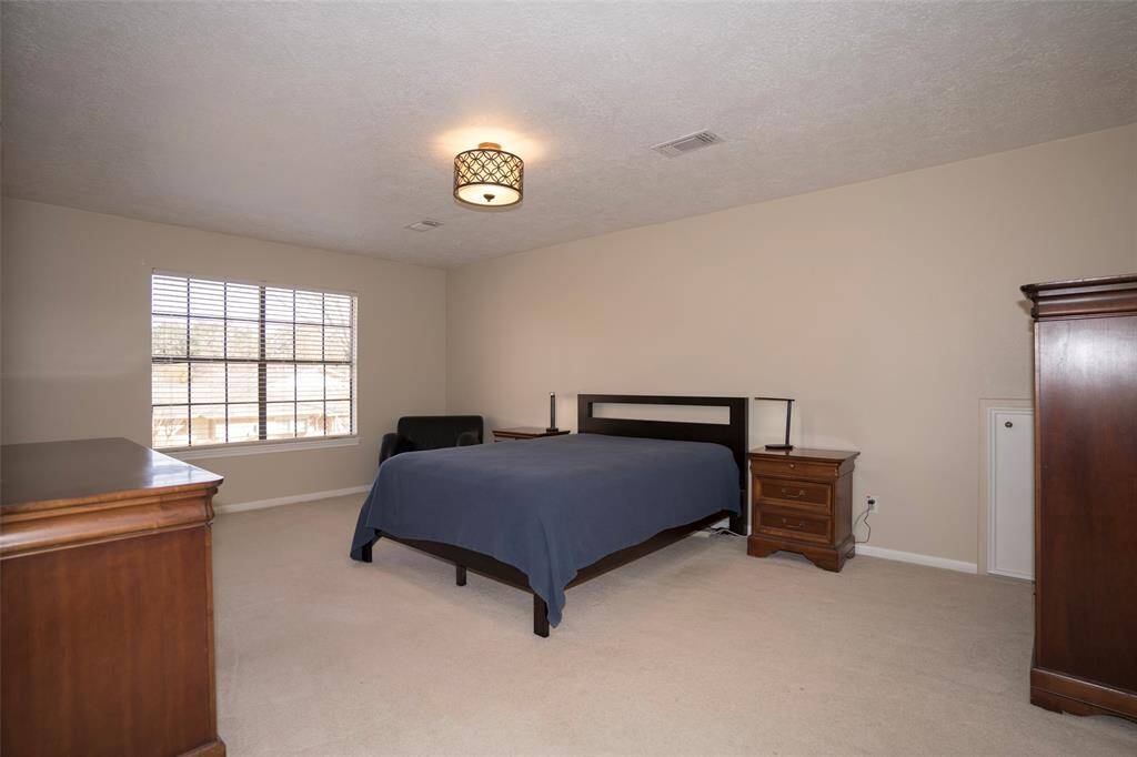 This spacious main bedroom offers plenty of room for relaxation and comfort.
