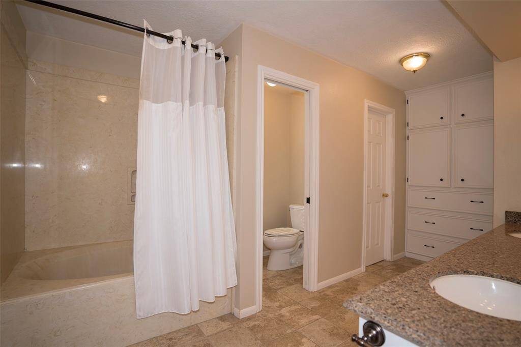The tub and shower area is accented with tiled walls, adding a touch of elegance to the space.