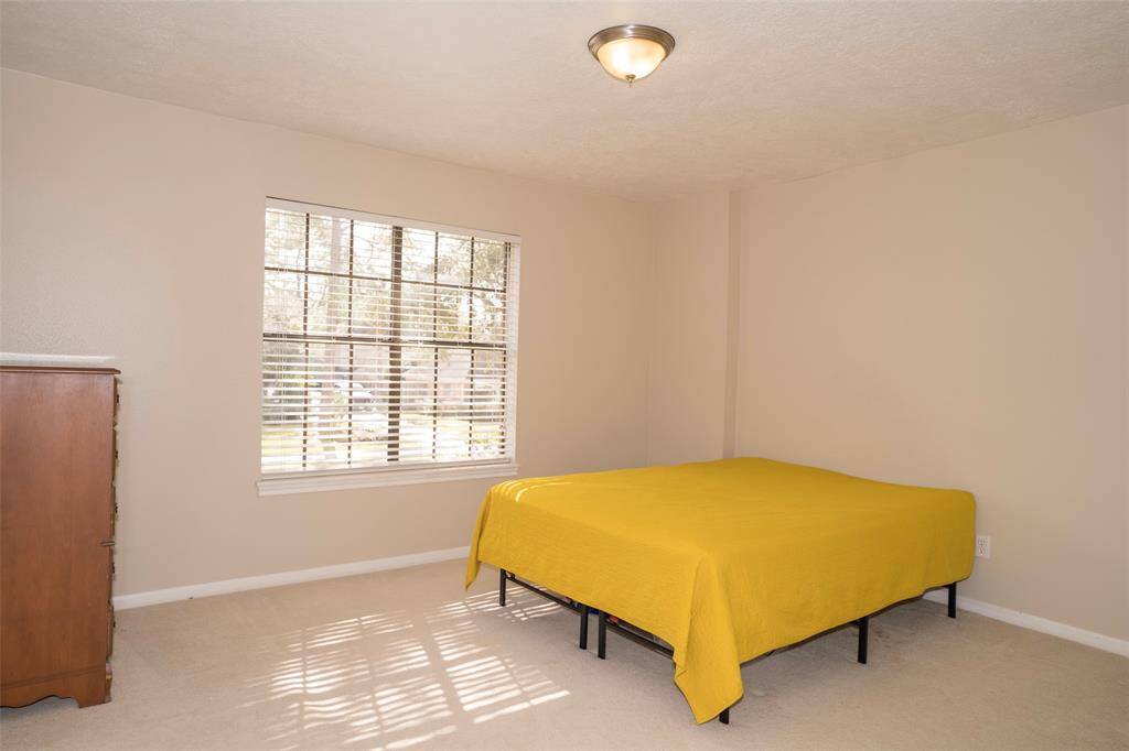 The last bedroom, featuring a large window that invites plenty of natural sunlight, creating a bright and airy atmosphere.