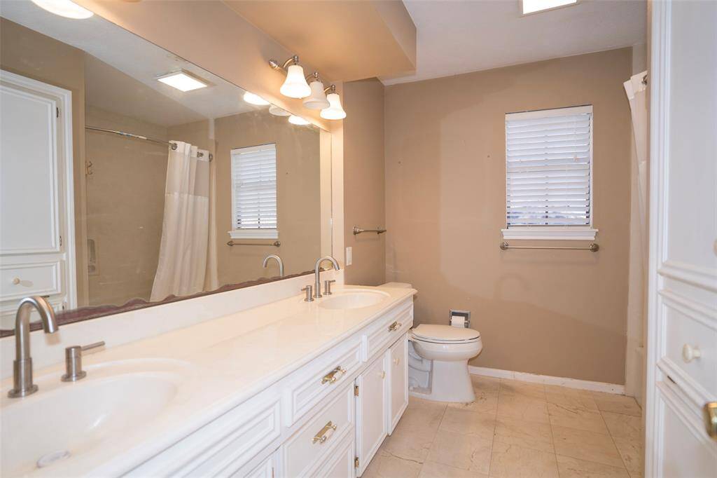 Another view of the bathroom from a different angle, highlighting its ample space for storage along with its functional design.