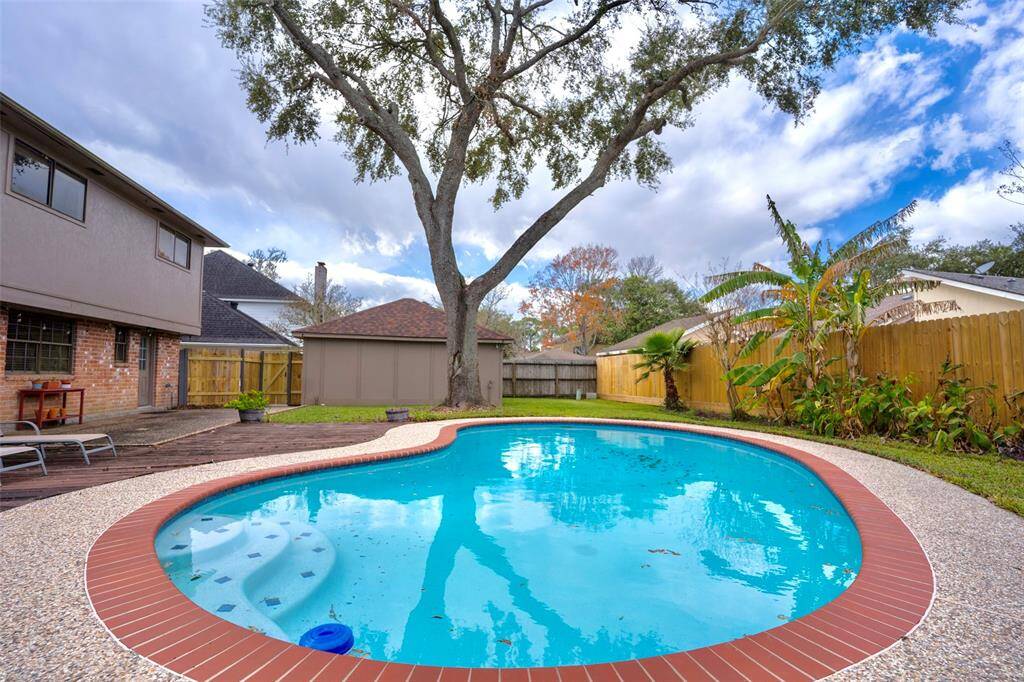 The backyard is surrounded by a tall wooden fence, providing privacy and a secluded outdoor space.