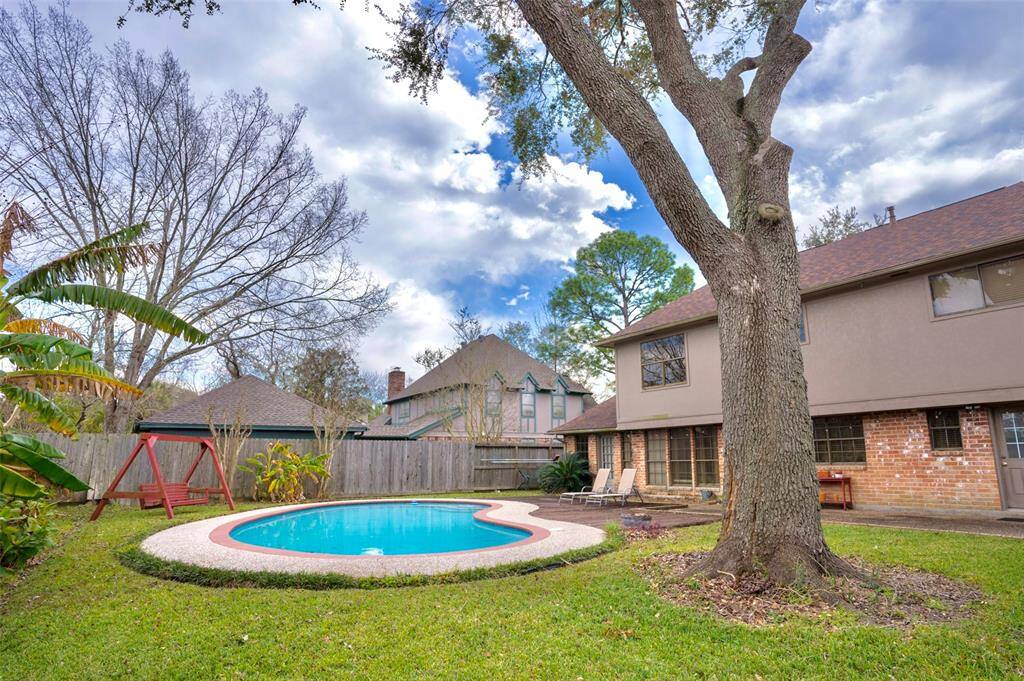 This view features a large tree and a glimpse of the inviting swimming pool, creating a peaceful outdoor oasis.