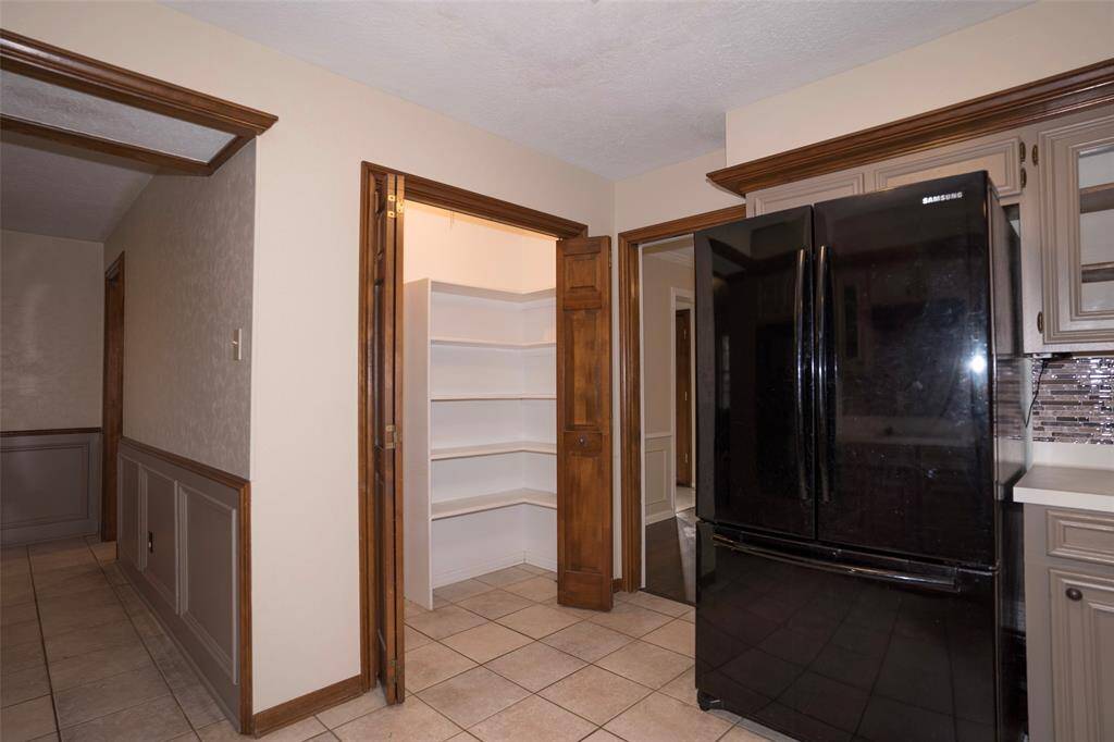 A clean and tidy kitchen with a spacious, empty pantry ready for your personal touch and organization.