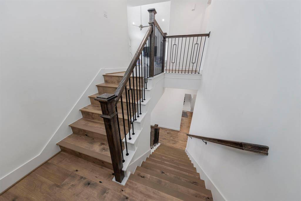 An elegant iron staircase gracefully ascends to the second floor, adding a touch of sophistication to the home’s design.