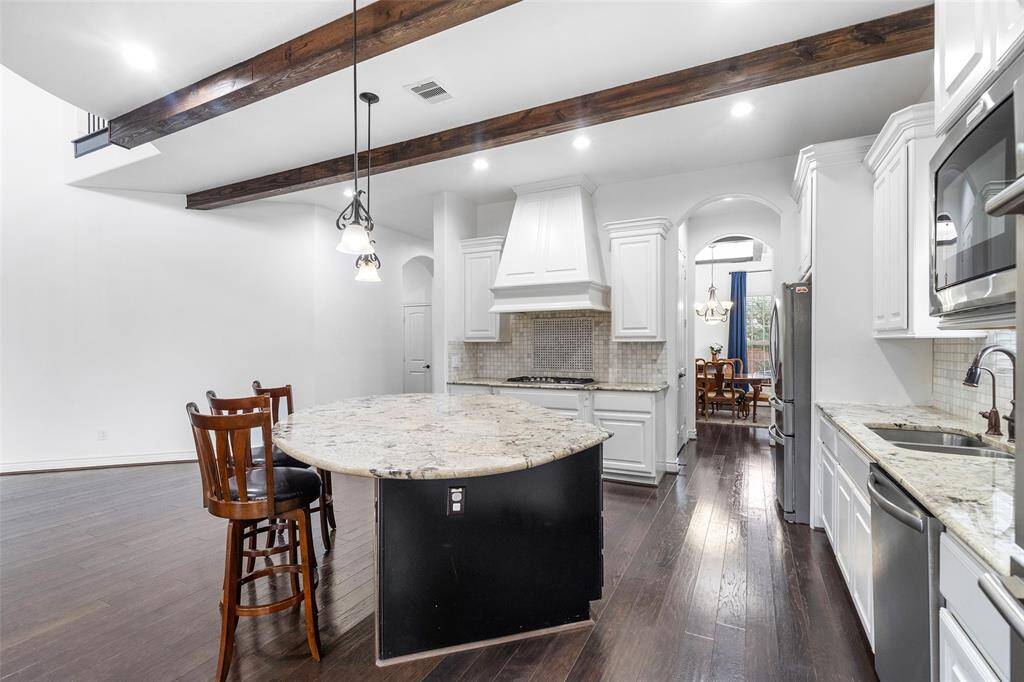 Notice the high end appliances in the kitchen including the custom vent hood, gas cooktop with plenty of counter space on each side.