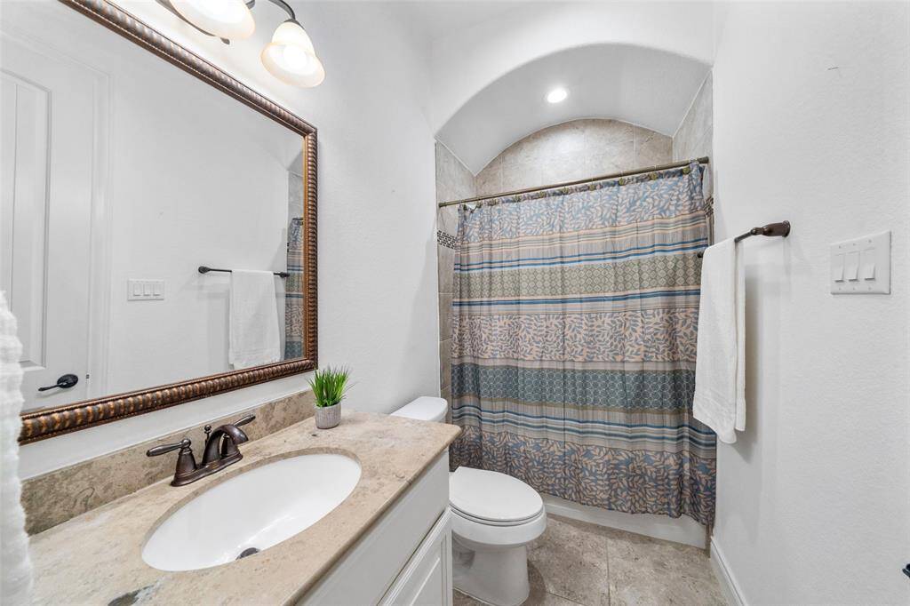 The ensuite bath for the downstairs bedroom is well-lit with recessed lighting, and the neutral color palette adds a clean, inviting feel.