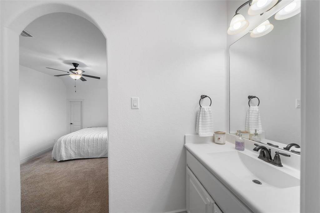 A clean, modern bathroom with a large mirror, single sink, and stylish fixtures is just between the 2 bedrooms upstairs. Each bedroom has a private sink area leading to a large bathroom.