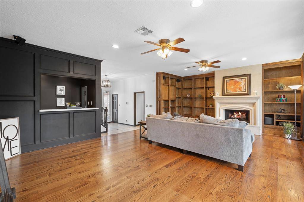 Built-in shelving with a hidden mounted TV, gaslog fireplace and a wet bar to welcome you home.